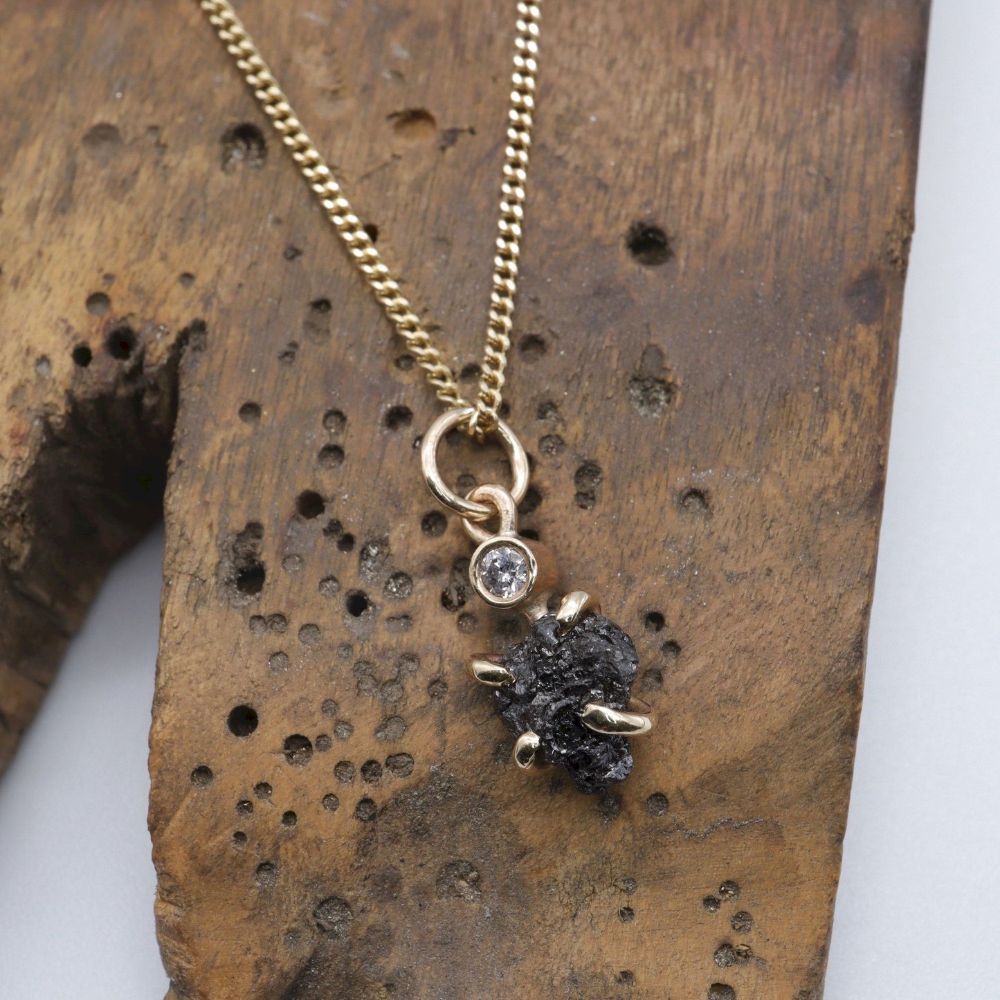 Black diamond pendant with one uncut and one faceted natural diamond