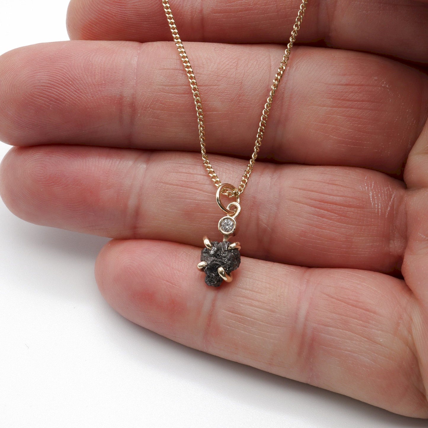 Black diamond pendant with one uncut and one faceted natural diamond