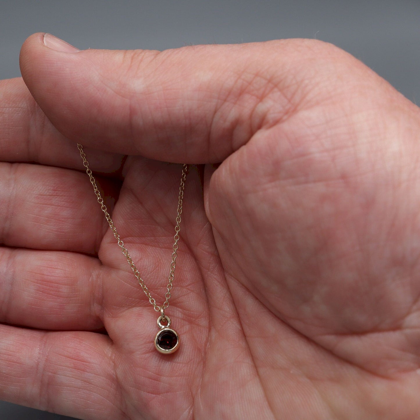 Yellow gold Garnet pendant with chain. January Birthstone