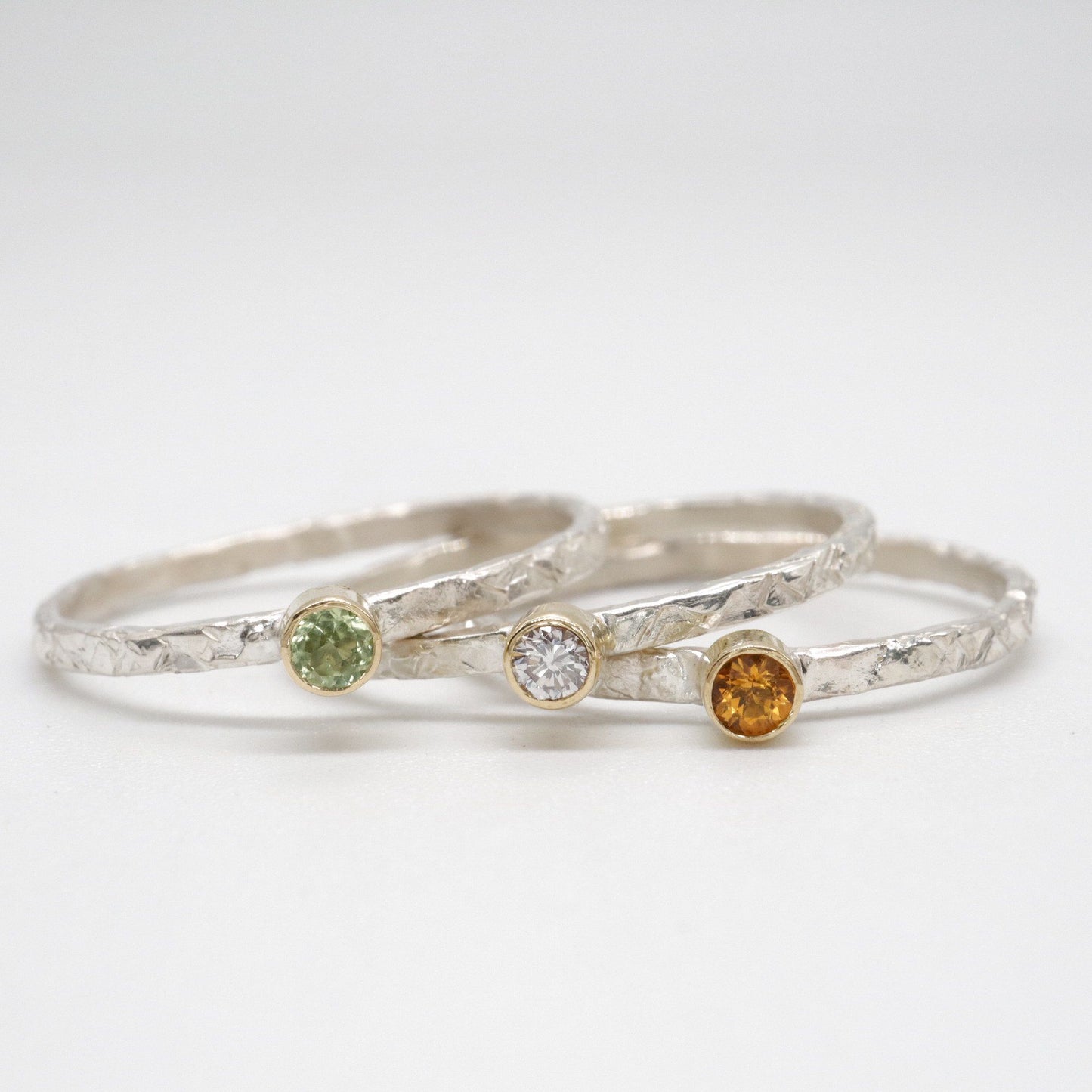 Ring set of three with peridot, diamond and citrine, Striding Edge stacking design in 18ct yellow gold and silver.