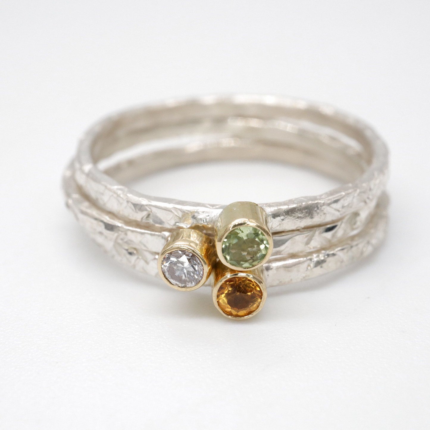 Ring set of three with peridot, diamond and citrine, Striding Edge stacking design in 18ct yellow gold and silver.