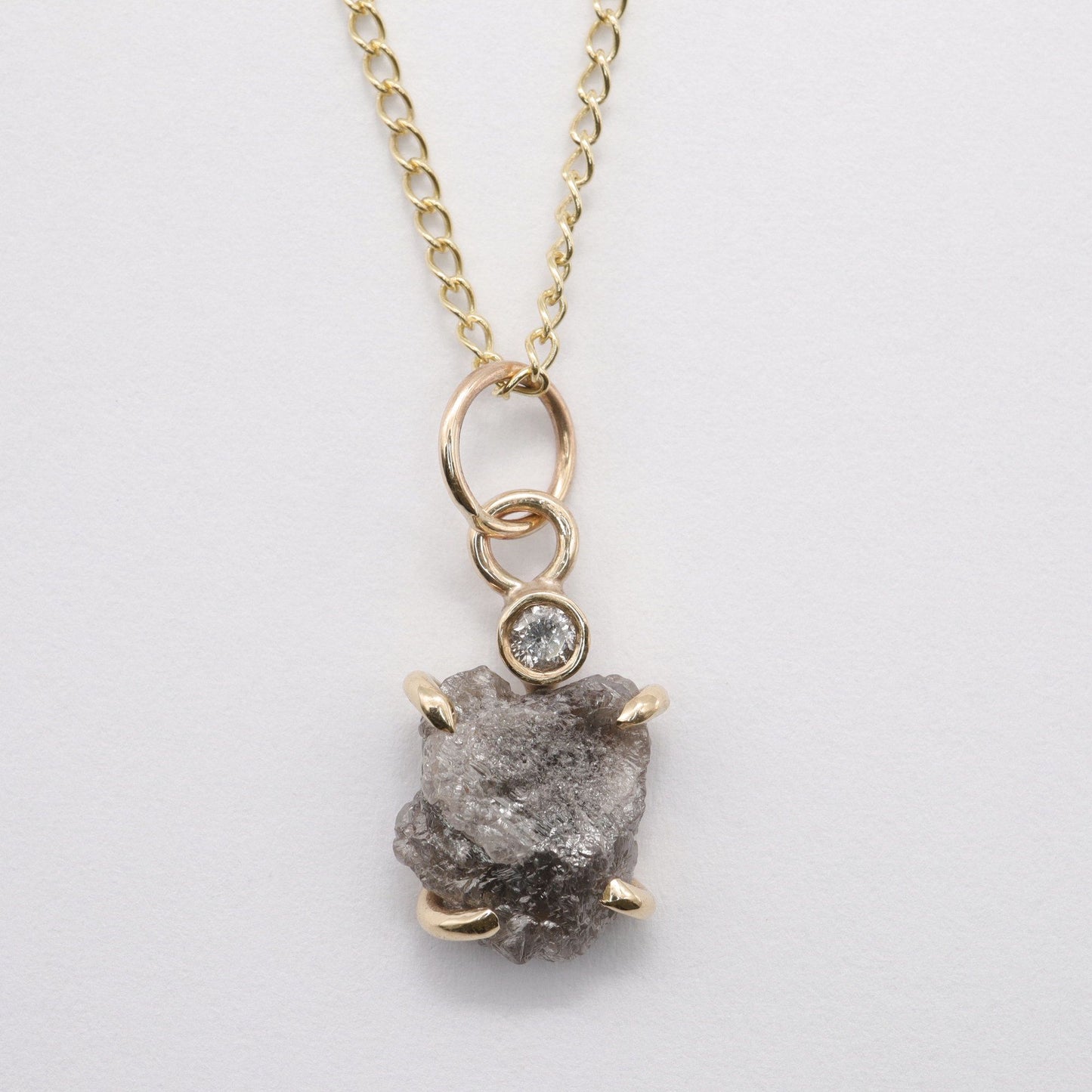 Diamond pendant with one uncut and one faceted natural diamond