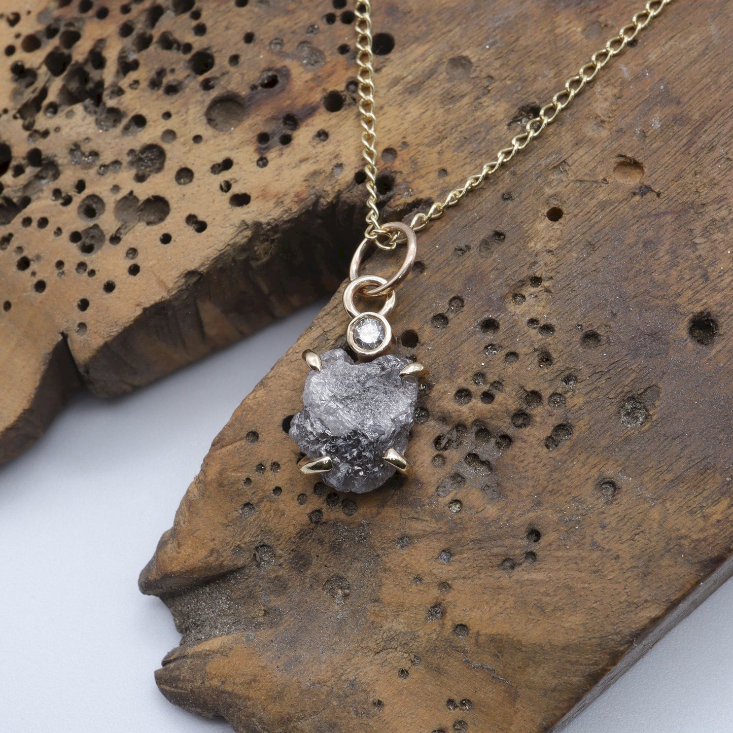 Diamond pendant with one uncut and one faceted natural diamond