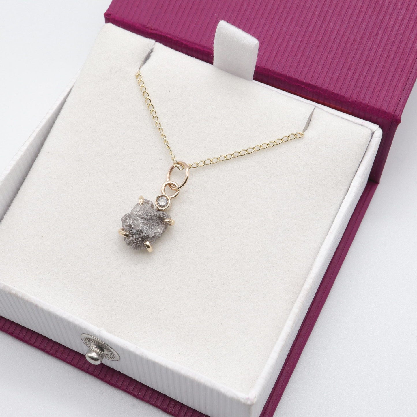 Diamond pendant with one uncut and one faceted natural diamond