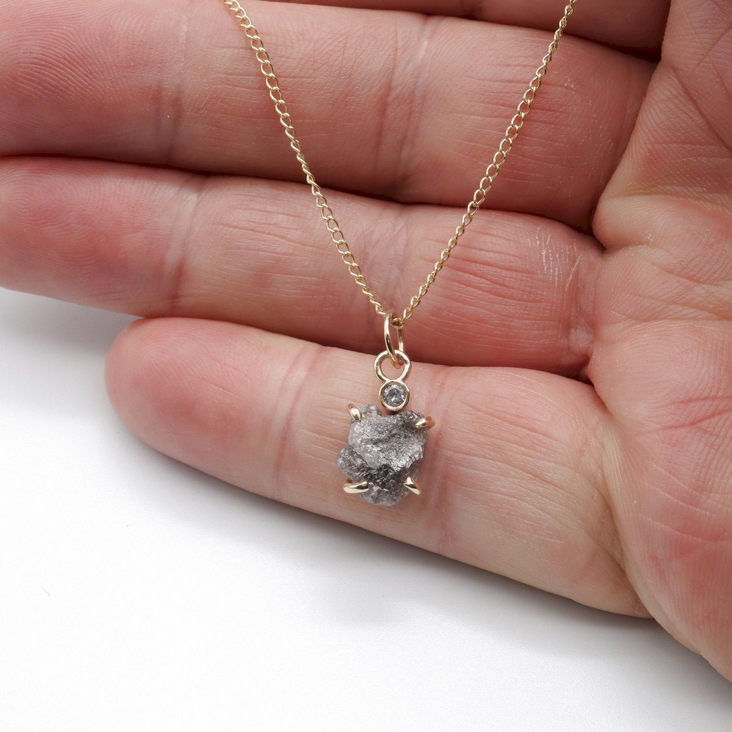 Diamond pendant with one uncut and one faceted natural diamond