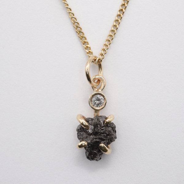 Black diamond pendant with one uncut and one faceted natural diamond