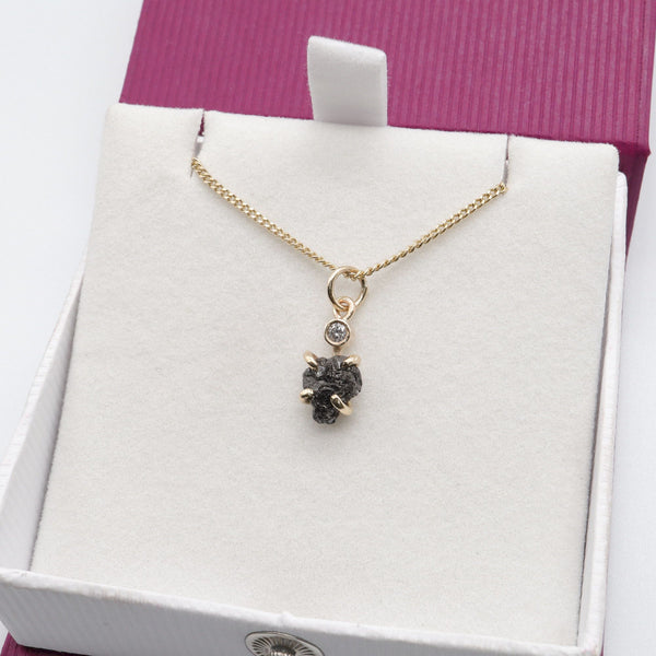 Black diamond pendant with one uncut and one faceted natural diamond