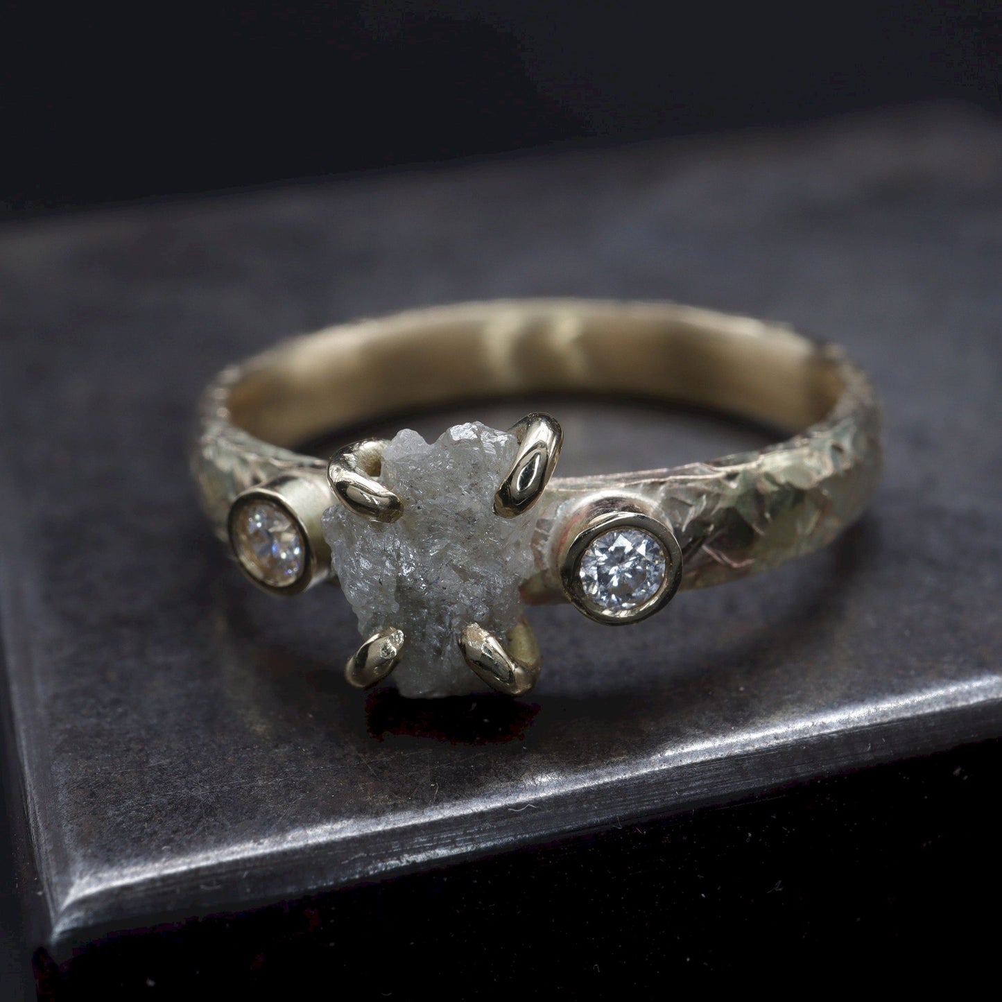 Diamond three stone gold ring set with raw uncut diamond.